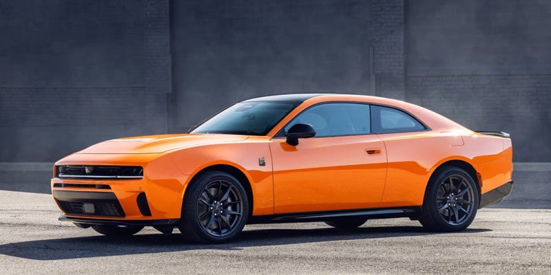 A professional lineup of next-generation Dodge vehicles parked in front of the dealership.