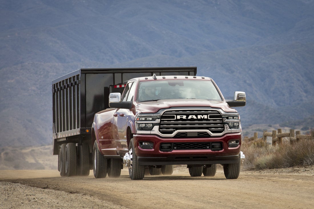 Heavy duty Ram diesel truck towing a large trailer on a highway in Wyoming
