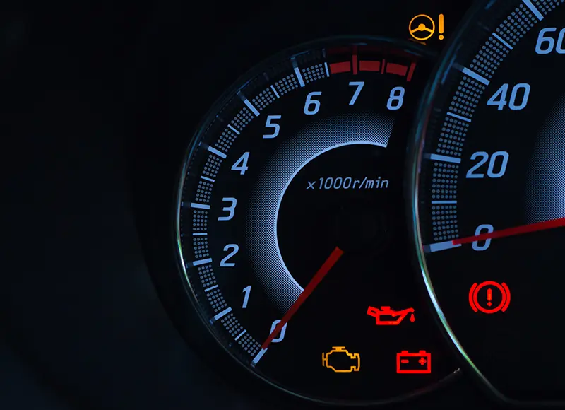 Automotive instrument cluster displaying active dashboard warning lights